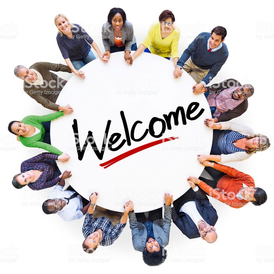 Group of People Holding Hands Around the Word Welcome